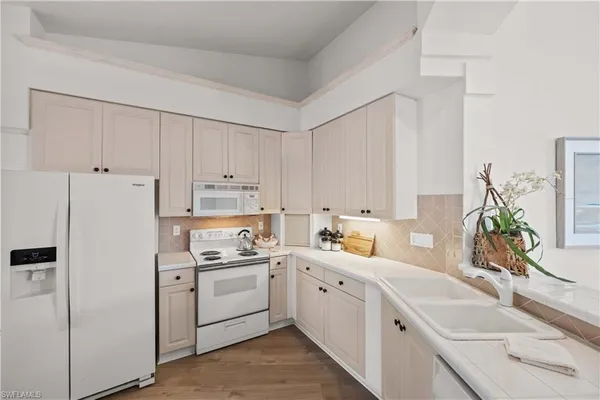 a kitchen with stainless steel appliances a stove a sink and white cabinets