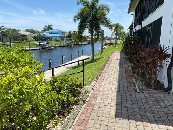 a view of a lake with a floor to ceiling window next to a yard