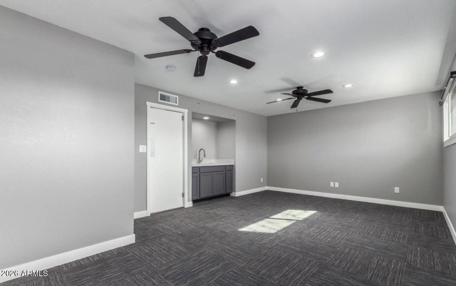 5130 West Redfield Road Glendale, AZ 85306 - Photo 17 of 35 a view of empty room with wooden floor and ceiling fan