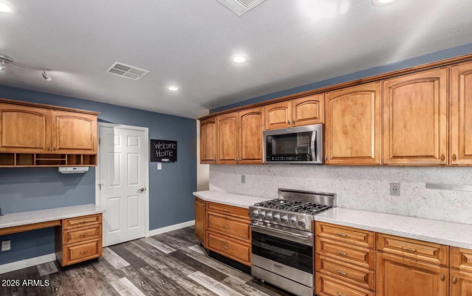 5130 West Redfield Road Glendale, AZ 85306 - Photo 4 of 35 a kitchen with stainless steel appliances granite countertop a stove a sink and a microwave