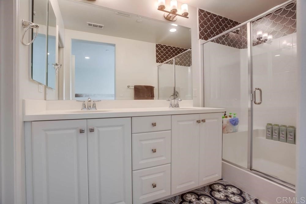 2229 Solara Lane Vista, CA 92081 - Photo 13 of 25 a bathroom with a double vanity sink a mirror and shower