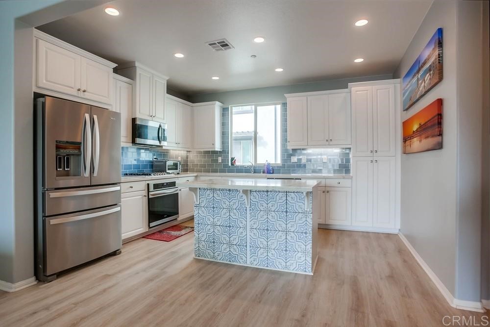 2229 Solara Lane Vista, CA 92081 - Photo 5 of 25 a kitchen with wooden floors appliances and cabinets
