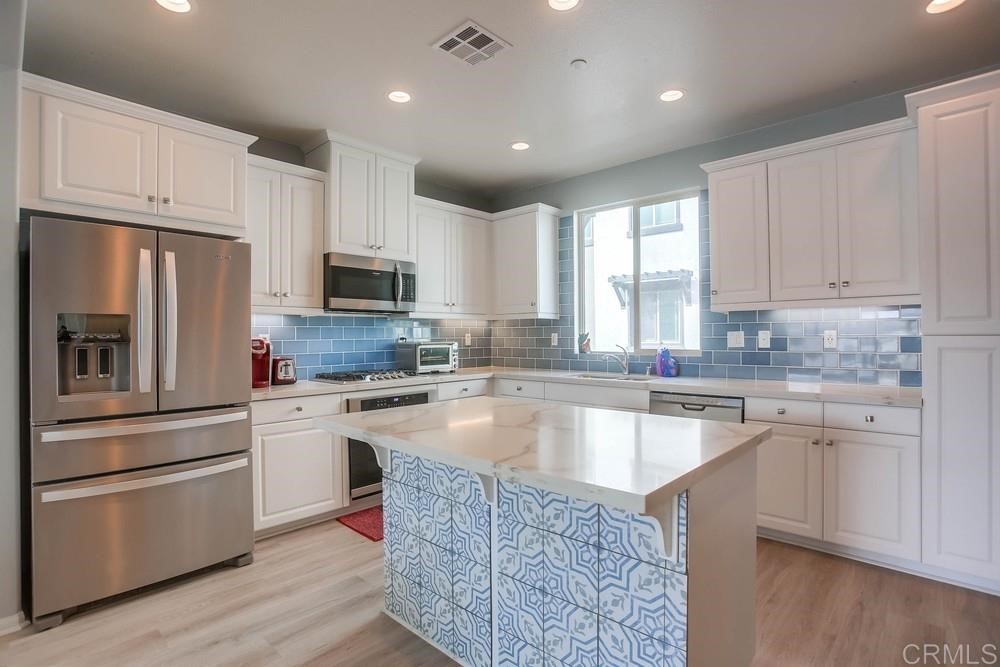 2229 Solara Lane Vista, CA 92081 - Photo 9 of 25 a kitchen with granite countertop a refrigerator stove top oven and sink