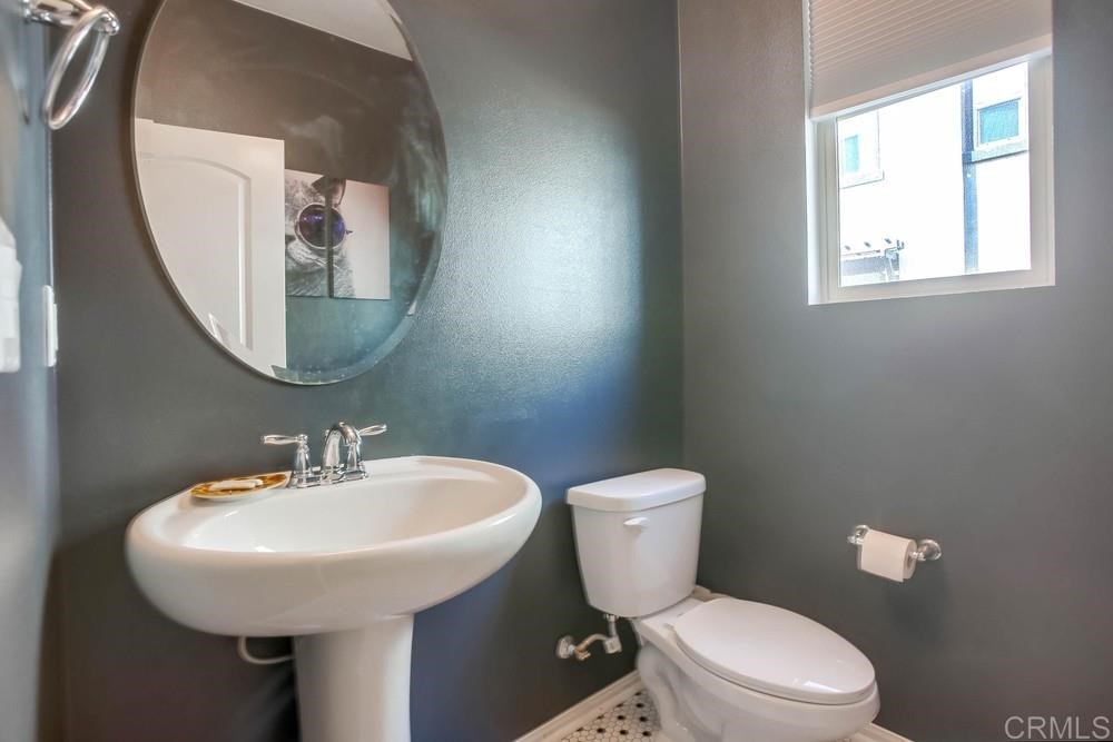 2229 Solara Lane Vista, CA 92081 - Photo 10 of 25 a bathroom with a toilet a sink and a mirror