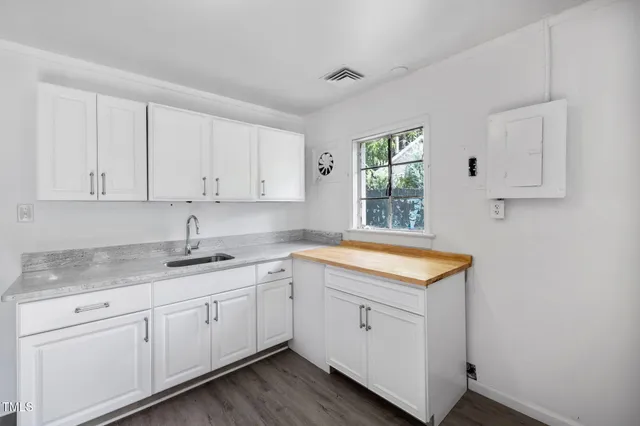 a kitchen with granite countertop white cabinets and a sink