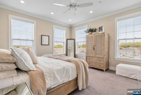 a spacious bedroom with a bed a couch and large window