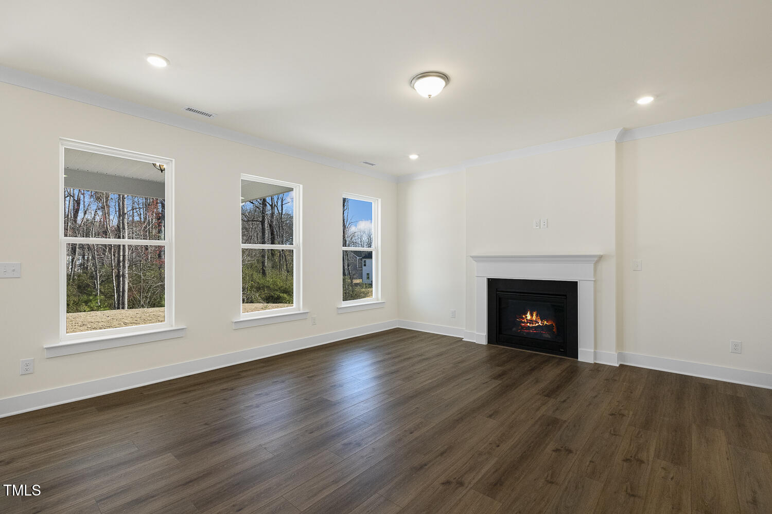 82 Gander Drive Benson, NC 27504 - Photo 9 of 33 an empty room with wooden floor fireplace and windows