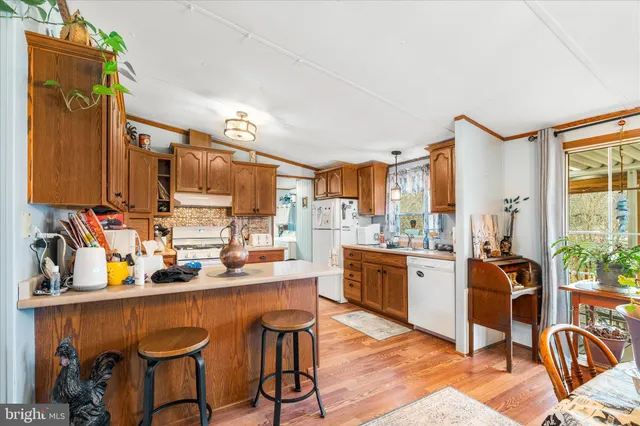 a kitchen with stainless steel appliances a sink a stove a refrigerator cabinets and dining table