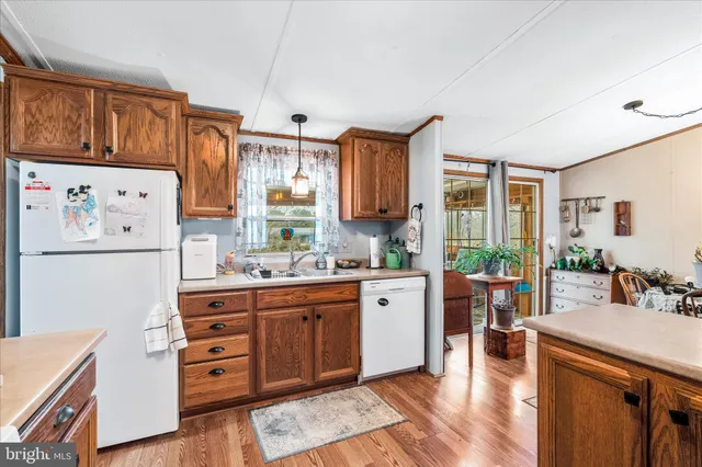 a kitchen with stainless steel appliances a stove a refrigerator a sink and wooden cabinets