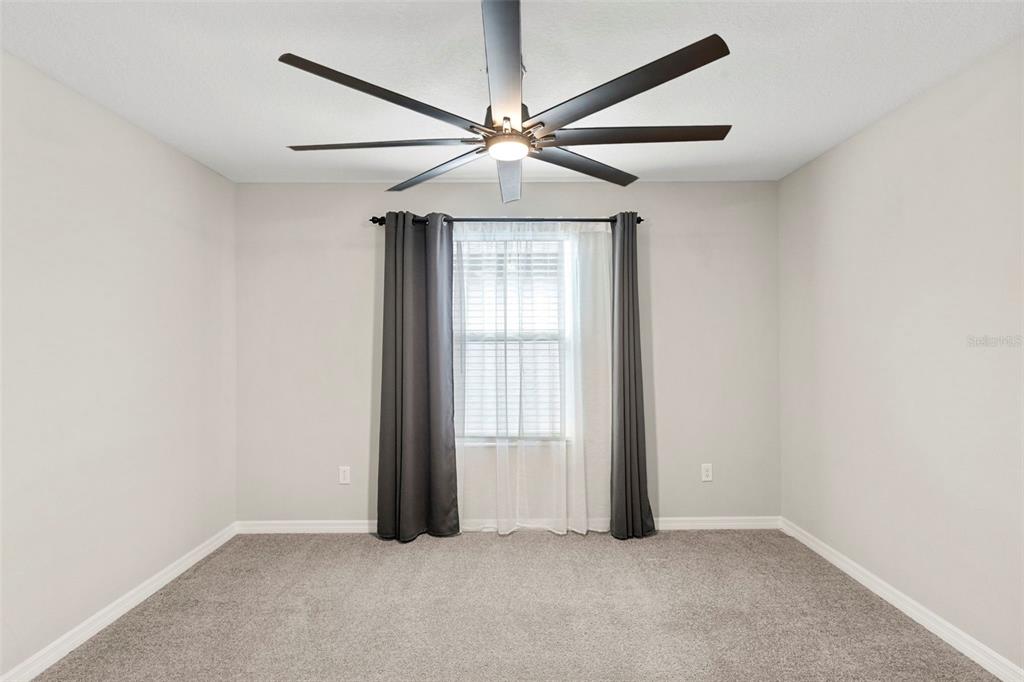 7537 Pool Compass Loop Wesley Chapel, FL 33545 - Photo 29 of 50 an empty room with chandelier fan and windows