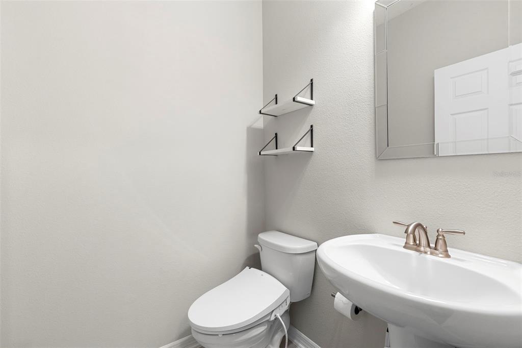 7537 Pool Compass Loop Wesley Chapel, FL 33545 - Photo 41 of 50 a white toilet sitting next to a bathroom sink