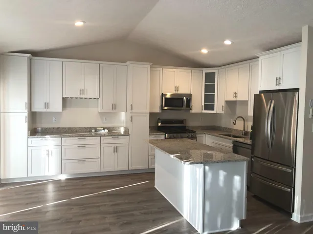 a kitchen with stainless steel appliances granite countertop a refrigerator stove microwave and sink