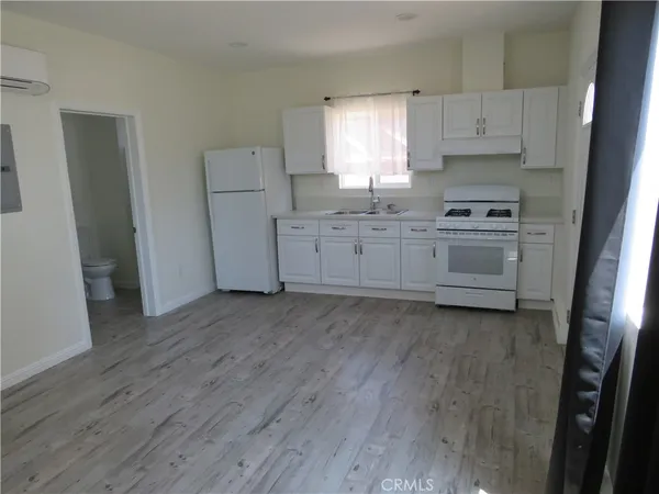 a kitchen with white cabinets and white appliances