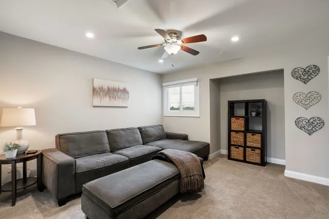 a living room with furniture and a ceiling fan