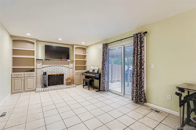 a living room with furniture a fireplace and a flat screen tv