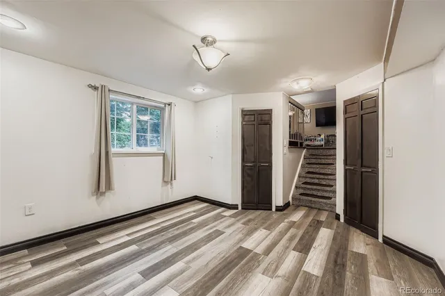 a view of a livingroom with wooden floor and stairs