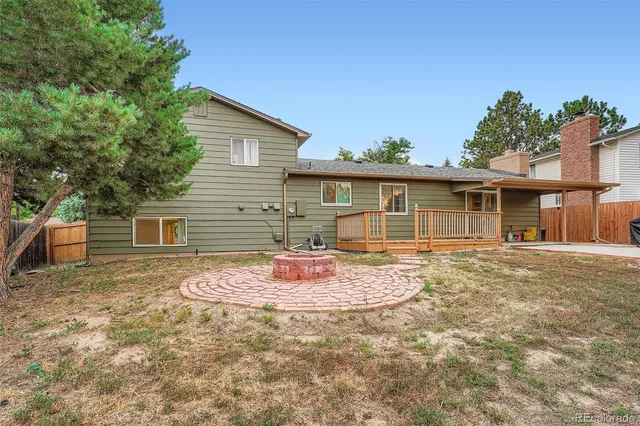 a backyard of a house with wooden floor and fence