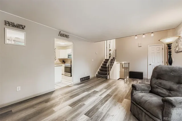 a living room with furniture and a wooden floor