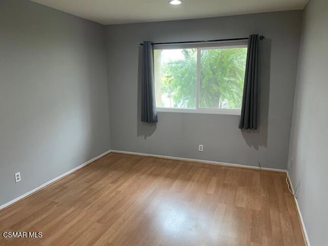 1256 Patricia Avenue, Unit 10 Simi Valley, CA 93065 - Photo 20 of 25 an empty room with wooden floor and windows