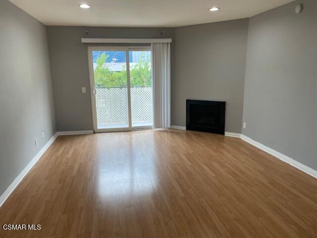 1256 Patricia Avenue, Unit 10 Simi Valley, CA 93065 - Photo 3 of 25 a view of an empty room with wooden floor and a window