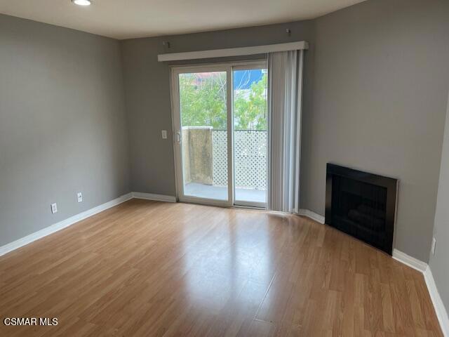 1256 Patricia Avenue, Unit 10 Simi Valley, CA 93065 - Photo 4 of 25 a view of an empty room with wooden floor and a window