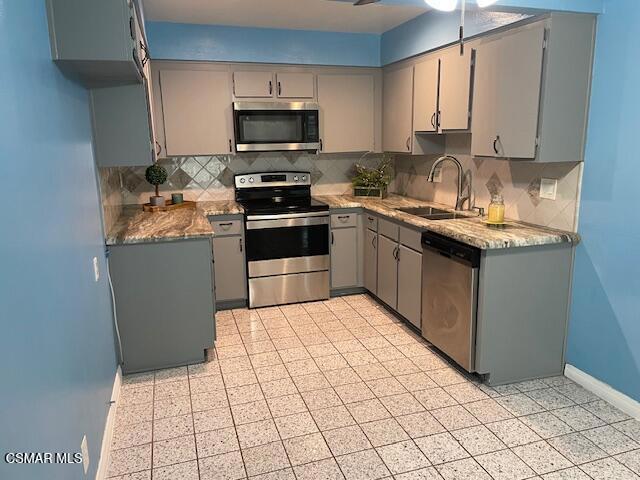 1256 Patricia Avenue, Unit 10 Simi Valley, CA 93065 - Photo 7 of 25 a kitchen with stainless steel appliances a sink a stove a microwave a refrigerator a sink and cabinets