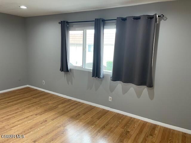 1256 Patricia Avenue, Unit 10 Simi Valley, CA 93065 - Photo 10 of 25 a view of an empty room with wooden floor and a window