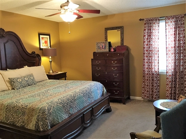 4967 Fulton Mill Road Macon, GA 31216 - Photo 12 of 28 a bedroom with a bed and a chandelier