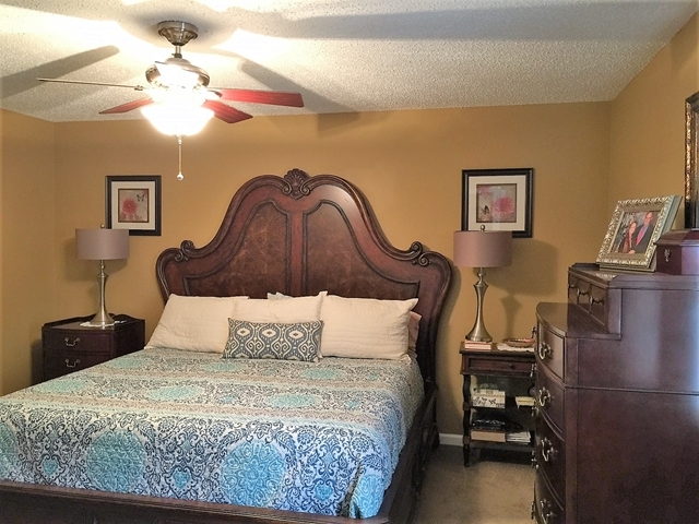 4967 Fulton Mill Road Macon, GA 31216 - Photo 13 of 28 a bedroom with a bed and a chandelier