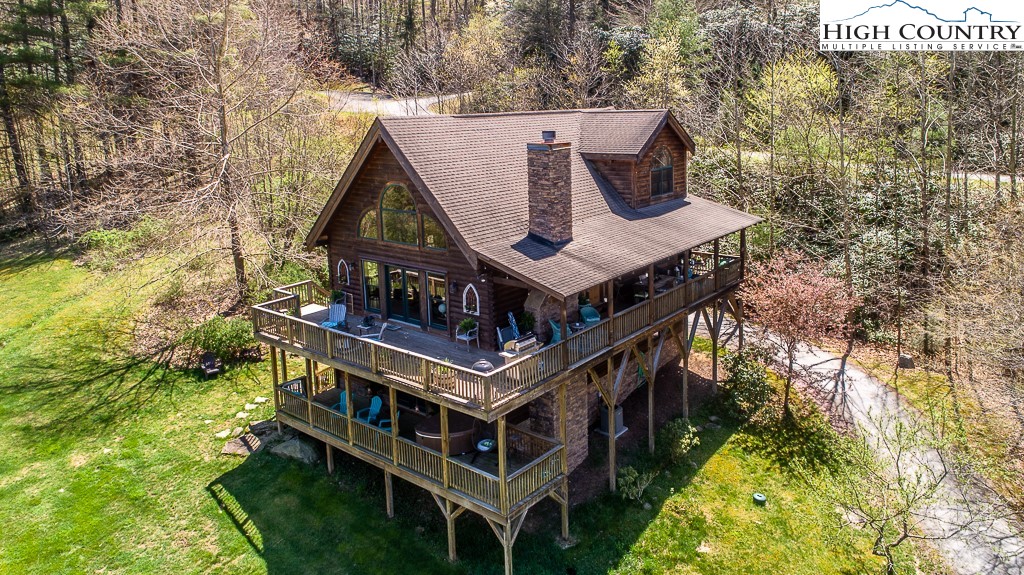 aerial view of a house with a yard and large trees