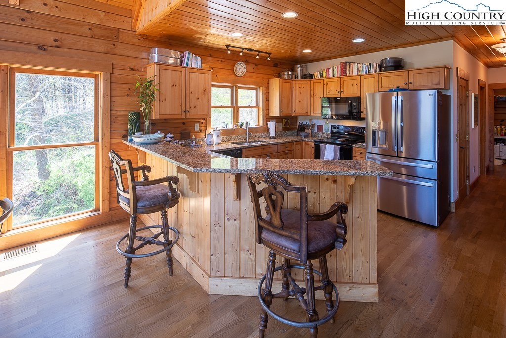 154 Lilac Lane Boone, NC 28607 - Photo 17 of 50 a kitchen with stainless steel appliances a dining table chairs refrigerator and sink