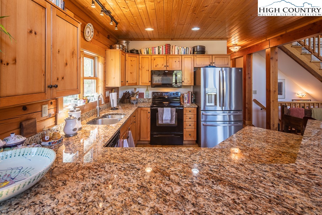 154 Lilac Lane Boone, NC 28607 - Photo 18 of 50 a kitchen with stainless steel appliances kitchen island granite countertop a refrigerator and a stove