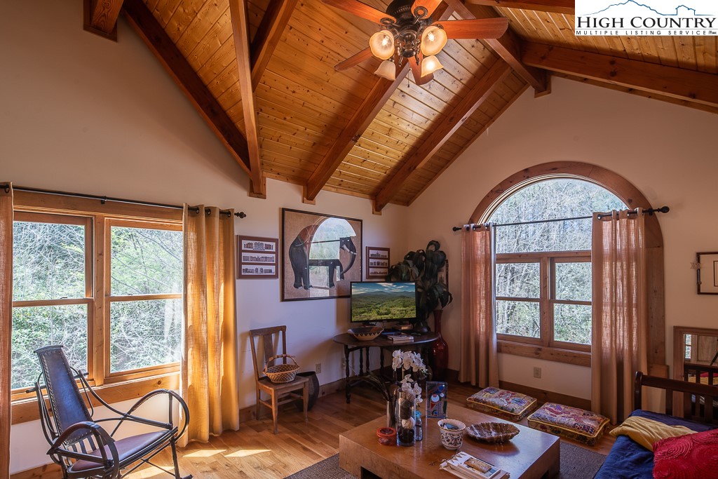 154 Lilac Lane Boone, NC 28607 - Photo 32 of 50 a living room with furniture a flat screen tv and floor to ceiling windows