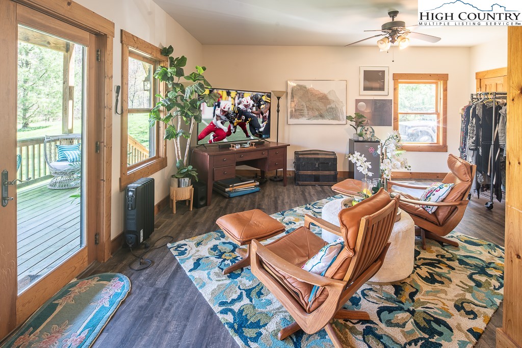 154 Lilac Lane Boone, NC 28607 - Photo 36 of 50 a living room with furniture a flat screen tv and a floor to ceiling window