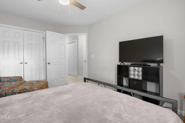 a view of an empty room with a fireplace and a chandelier fan
