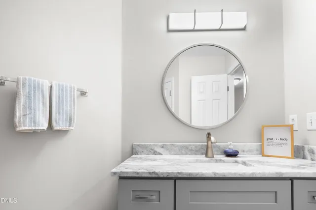 a bathroom with a granite countertop sink a mirror and vanity