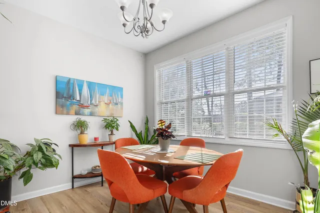 a dining room with furniture a large window and potted plants