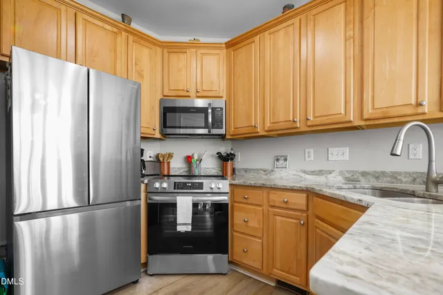 a kitchen with stainless steel appliances granite countertop a refrigerator stove a sink and a microwave