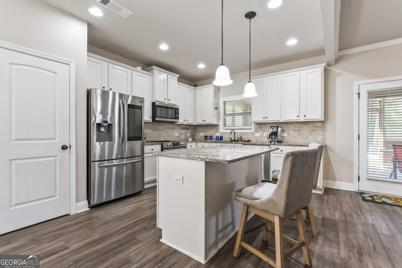 643 Patillo Road Stockbridge, GA 30281 - Photo 11 of 30 a kitchen with kitchen island granite countertop a sink a center island and stainless steel appliances