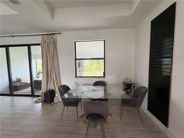 a living room with furniture kitchen view and a chandelier