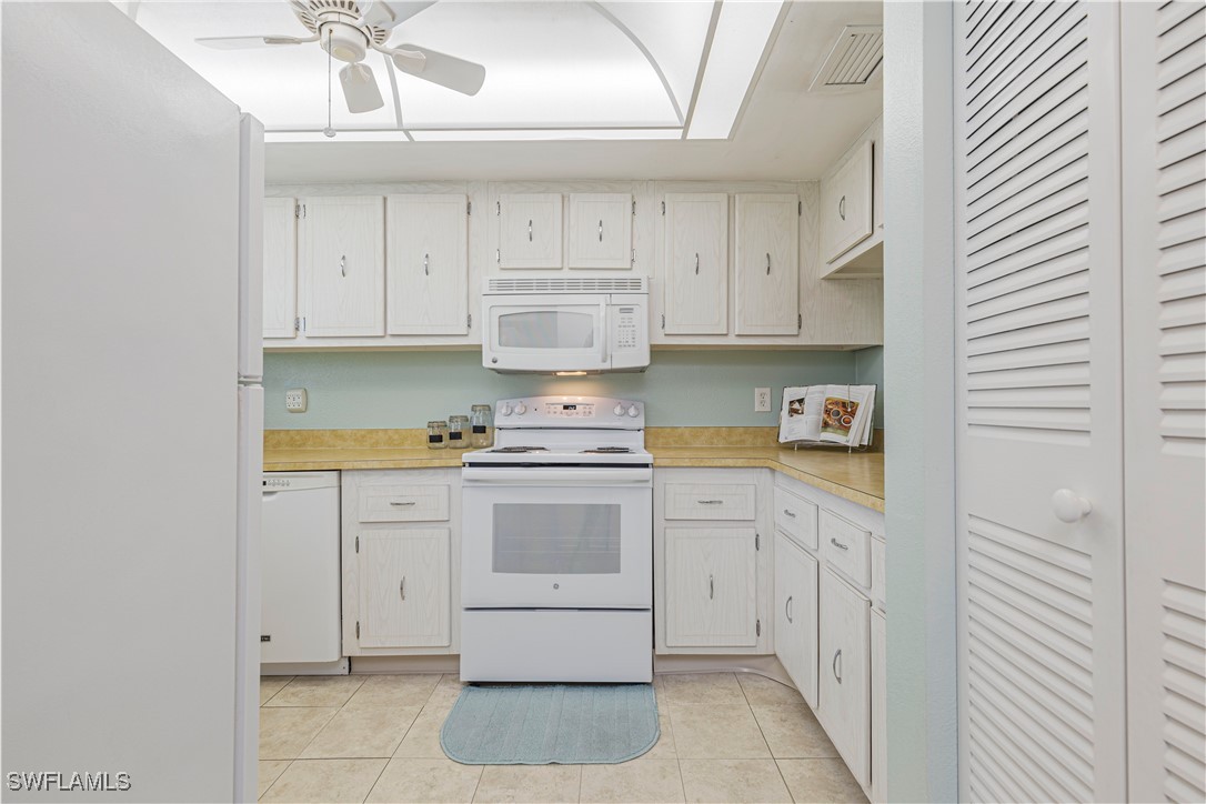 7043 New Post Road, Unit 7 North Fort Myers, FL 33917 - Photo 14 of 26 a kitchen with white cabinets and white appliances