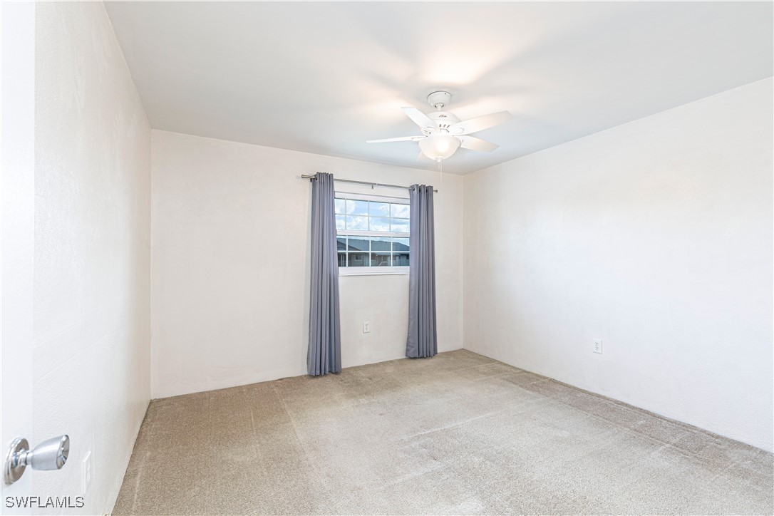 7043 New Post Road, Unit 7 North Fort Myers, FL 33917 - Photo 18 of 26 an empty room with windows and fan