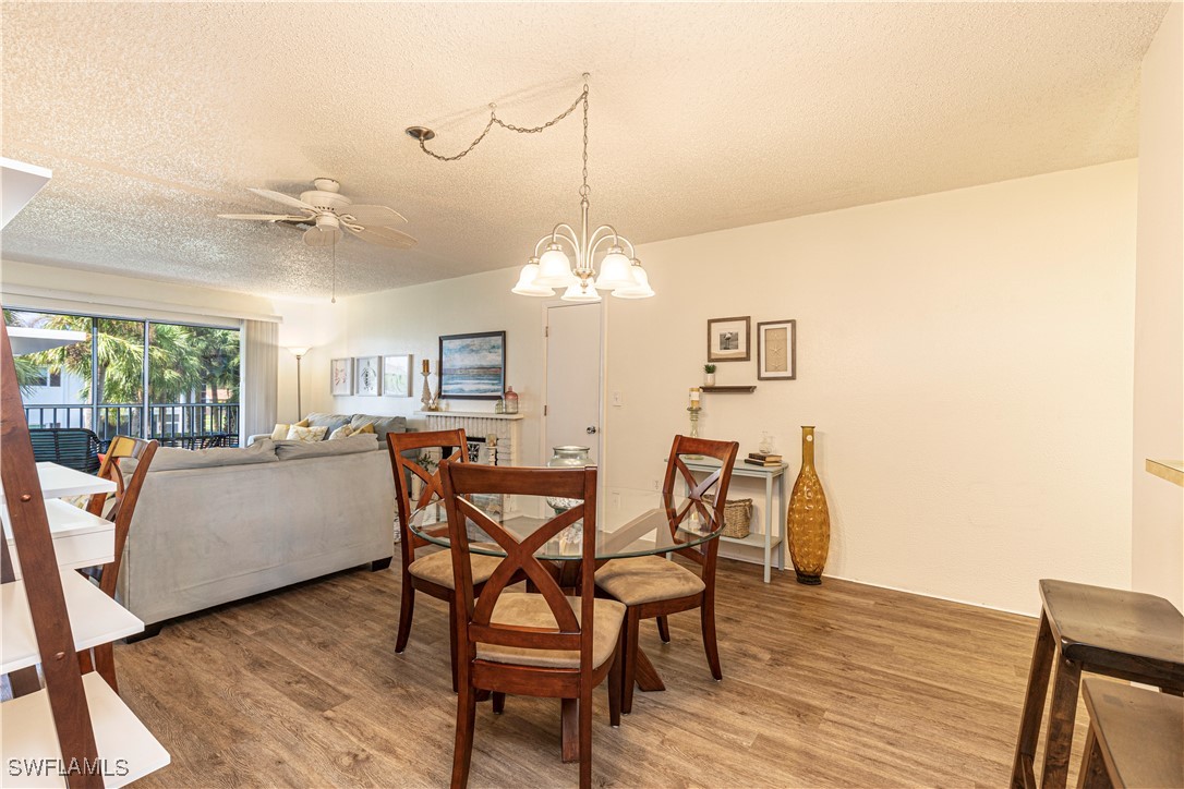 7043 New Post Road, Unit 7 North Fort Myers, FL 33917 - Photo 9 of 26 a dining room with furniture a chandelier and wooden floor
