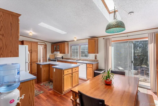 a kitchen with a table chairs and wooden floor