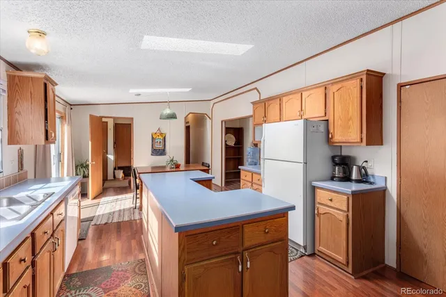 a kitchen with kitchen island wooden floors and stainless steel appliances