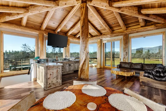 a kitchen with a counter top windows and view of living room