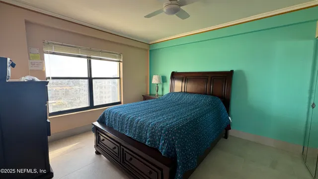 a bed sitting in a bedroom next to a window