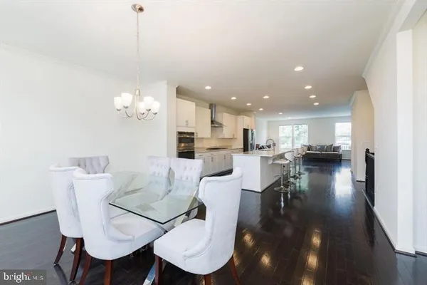 a view of a dining room and livingroom with furniture wooden floor a chandelier