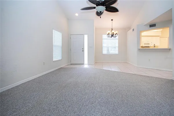 en empty room with windows and ceiling fan