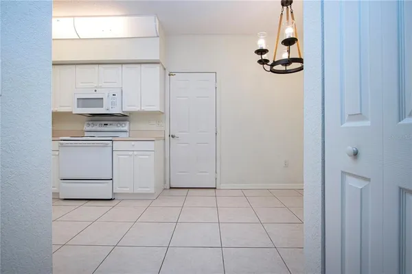 a kitchen with white cabinets and appliances